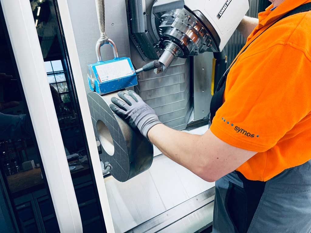 Mitarbeiter richtet ein Werkstück in der Maschine ein