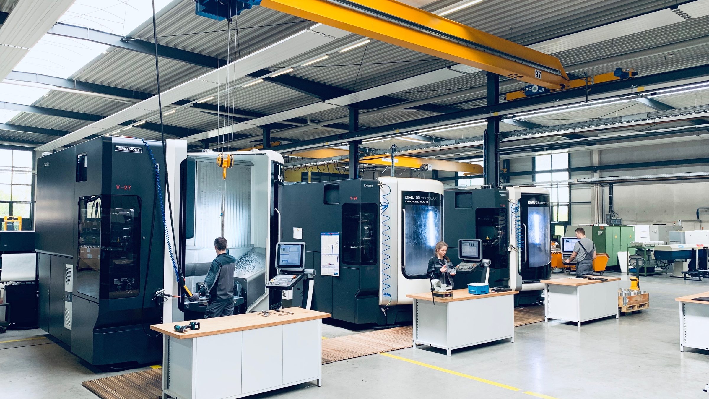 Fertigungshalle der symos GmbH: CNC-Bearbeitungszentren mit Arbeitsplätzen